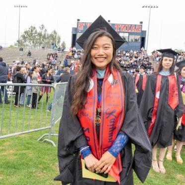 Graduate wearing a stole that says Master of Leadership